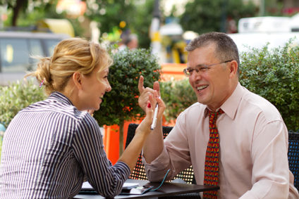 Business people laughing at lunch in a cafe outdoors