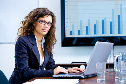 Young businesswoman working on laptop computer with growth chart in background