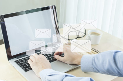 Businessman typing on laptop, shadows of envelopes
