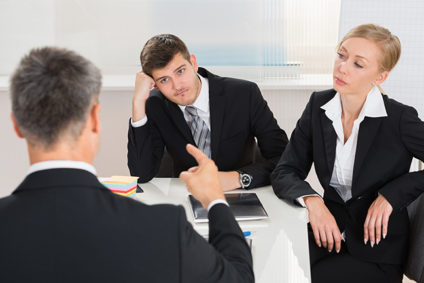 Three business colleagues arguing while seated at table