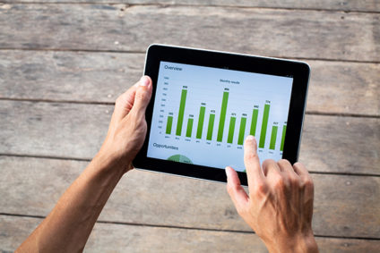 Tablet with green chart in hands of businessman