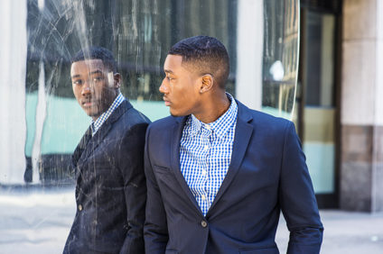 Young black businessman looking at his reflection