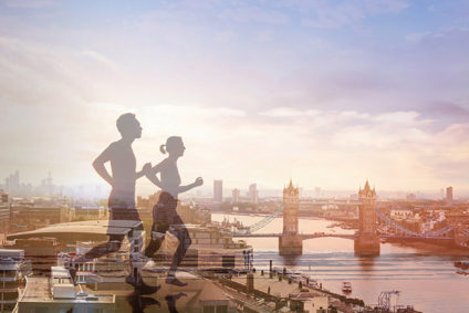 Male and female runners silhouetted against London Bridge