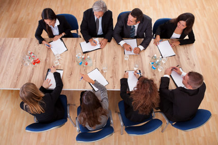 Overhead shot of eight businesspeople meeting around a table