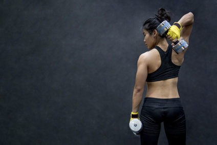 Young Asian woman lifting dumbbells