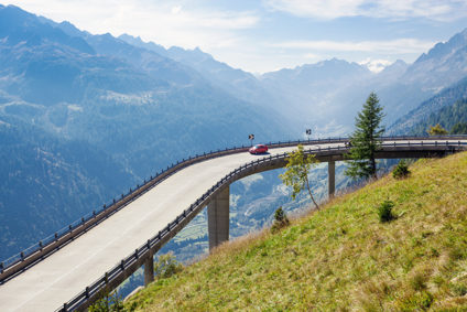 Car driving on road on pillars through Swiss mountains