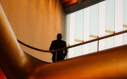 View from below of man standing on mezzanine with back to camera