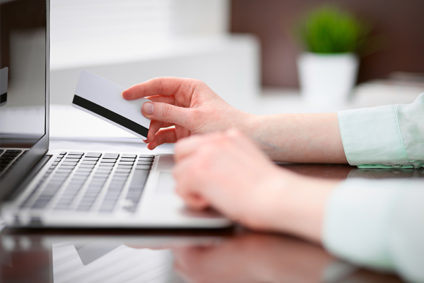 Woman at laptop holding credit card