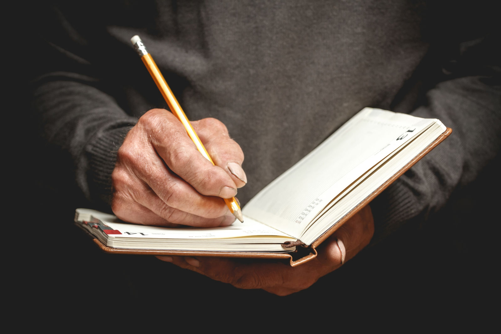 man writing in notebook