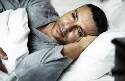 man lying awake in bed