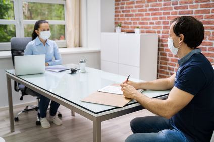 two masked people meeting in an office
